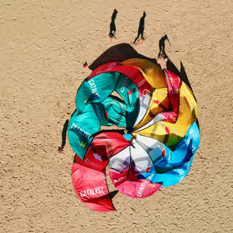 Vue aérienne d'ailes de kite étalées sur le sable