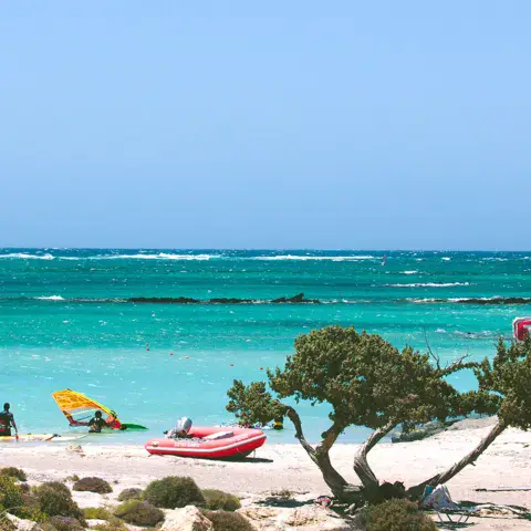 Plage et lagon avec windsurfeurs au large