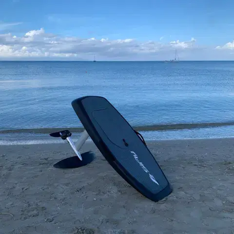 Planche eFoil posée sur le sable au bord de l'eau