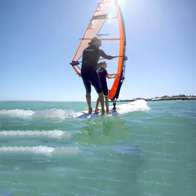 Cours de windsurf, deux personnes sur la même planche