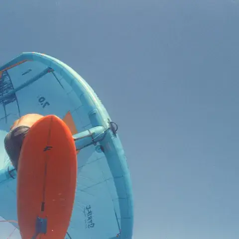 Aile de wing foil bleue et planche orange vues du dessous