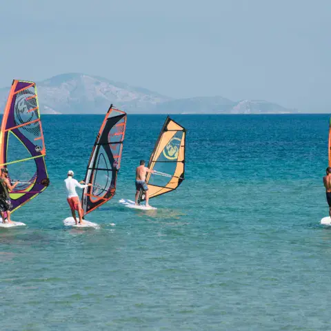 Windsurfeurs en séance devant la côte lointaine