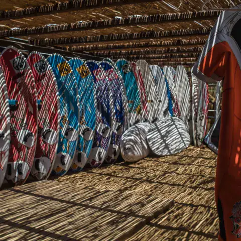 Planches de windsurf rangées sous l'abri de la station