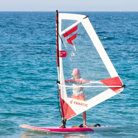 Windsurfeur débutant sur une planche rose
