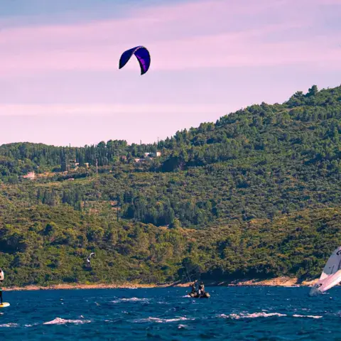 Kite et wing sur l'eau devant la côte