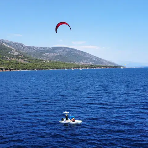 Kite en vol et bateau d'école au large