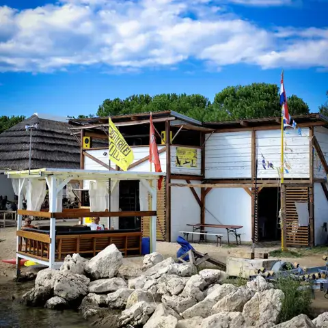 Le centre vu depuis la mer, bâtiment en bois et drapeaux