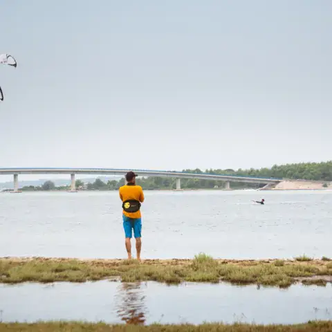 Pratiquant de kitesurf sur la rive, aile en vol au-dessus de l'eau