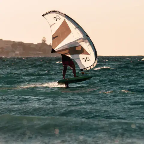 Rider de wing foil en action en fin de journée