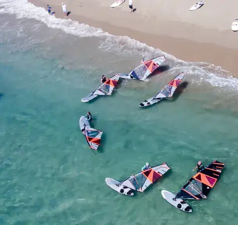 Groupe de windsurfeurs dans l'eau peu profonde