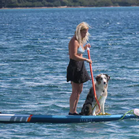 Pratiquante de paddle avec son chien