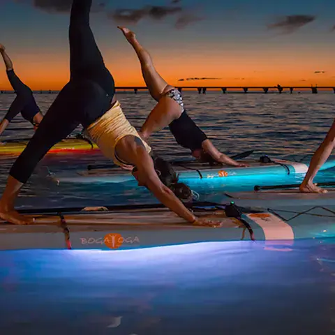SUP yoga au crépuscule sur des planches éclairées