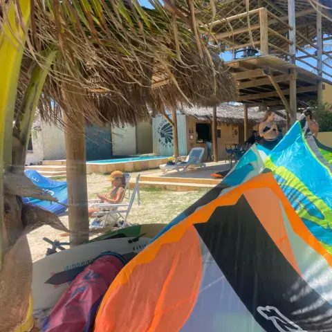 Kite déployé au bord de la plage avec cabanes en arrière-plan