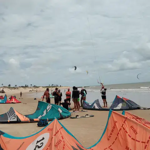 Groupe de kitesurfeurs posant sur la plage