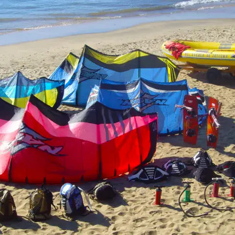 Kites étalés sur la plage avec le bateau d'appui