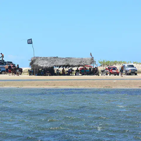 Abri de plage et véhicules au bord de l'eau