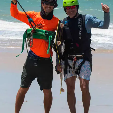 Moniteur et élève équipés de harnais et casques sur la plage