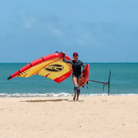 Aile de wing foil jaune et rouge sur la plage