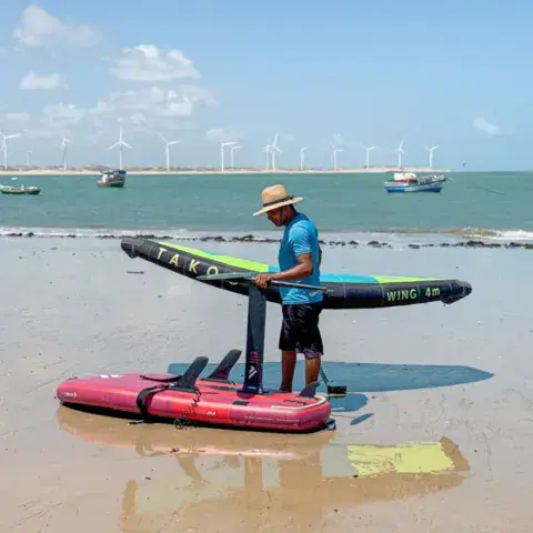 Aile et planche de foil posée sur le sable mouillé