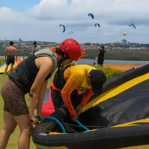 Préparation d'un kite sur la pelouse, d'autres kites en vol