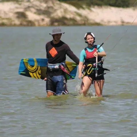 Instructeur et élève dans l'eau avec la planche