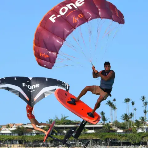 Rider en wing foil avec une aile rouge