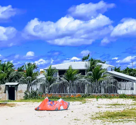 Maison de plage avec un kite posé sur l'herbe devant
