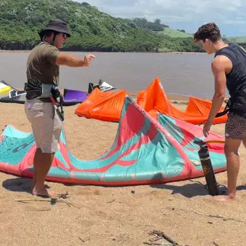 Préparation d'un kite sur la plage avec un moniteur