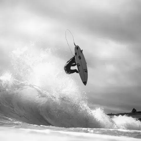 Surfeur en aérien au-dessus d'une vague