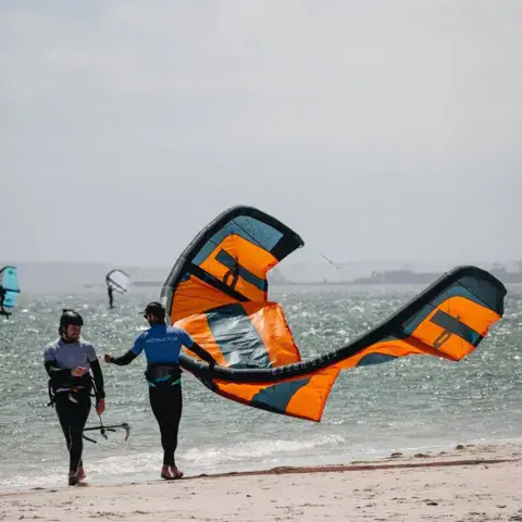 Élèves manipulant une aile sur la plage