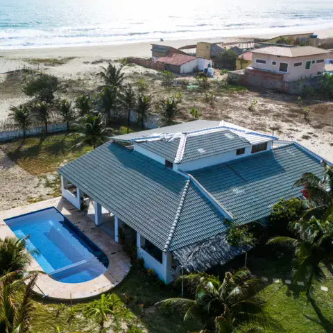 Vue aérienne de la maison et de sa piscine près de la plage
