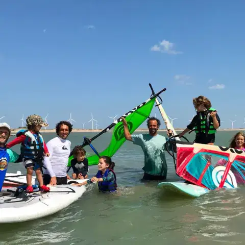 Groupe d'élèves et de moniteurs dans l'eau avec leur matériel