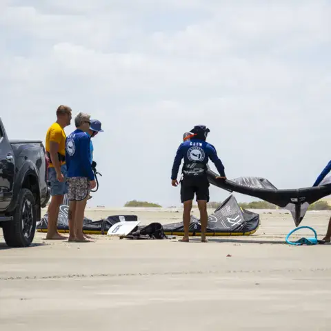 Préparation de kites sur la plage avec un pick-up