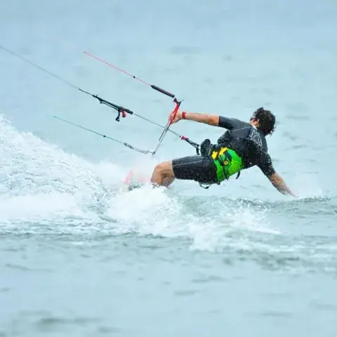 Kitesurfeur en saut sur le lac, pont en arrière-plan