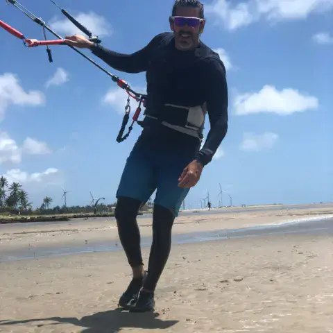 Kitesurfeur avec sa barre sur la plage