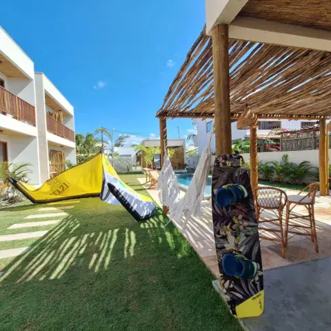 Jardin des chalets avec kite et planche posés près de la pergola