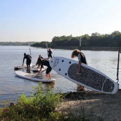 Groupe de stand up paddle au bord du lac