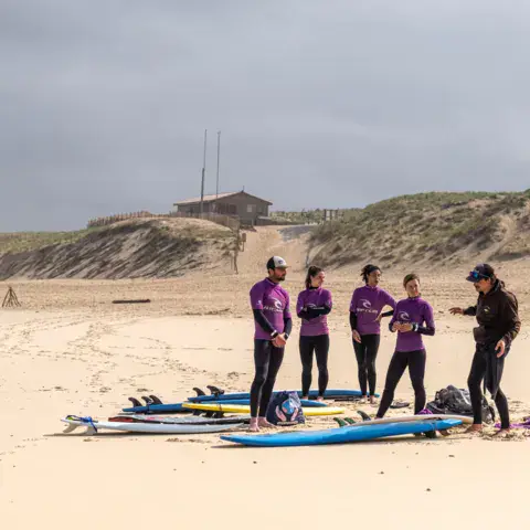 Groupe d'élèves et planches en mousse sur la plage
