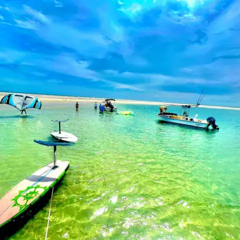 Aile de wing et foilboard sur une eau turquoise