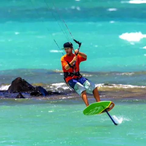 Rider en kitefoil près des rochers