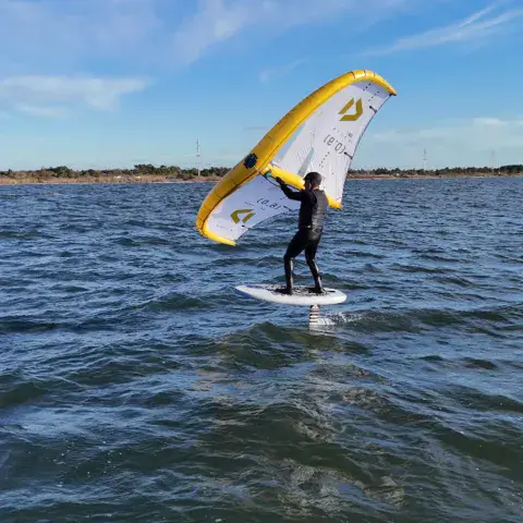 Pratiquant de wing foil avec une aile jaune