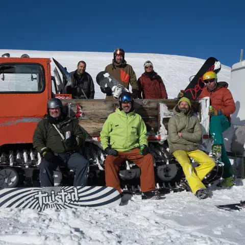 Riders avec leur matériel devant le 4x4 chenillé du lodge
