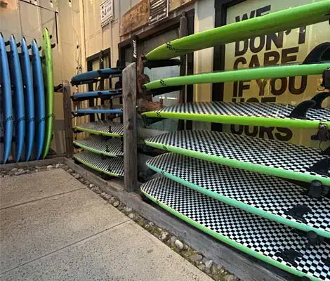 Planches de surf de location rangées sur des râteliers
