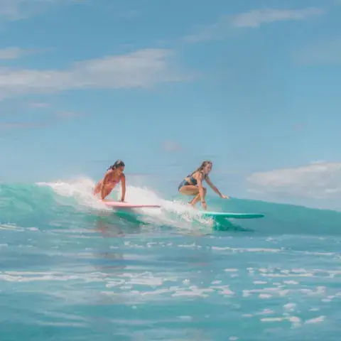 Deux surfeuses sur une vague