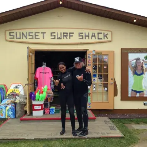 L'entrée du magasin, avec des bodyboards et des planches exposés