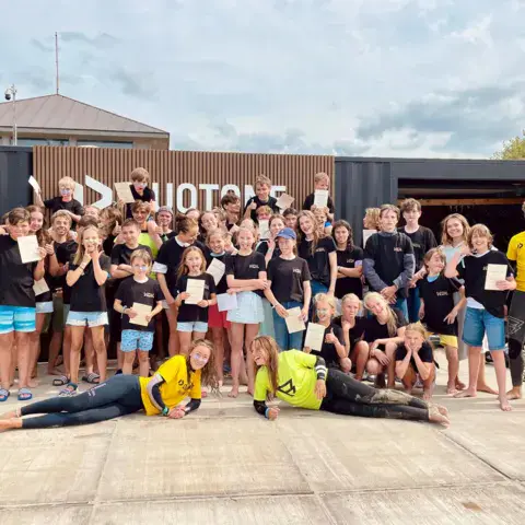 Groupe de jeunes d'un camp devant le bâtiment du club