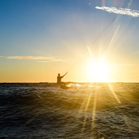 Kitesurfeur à contre-jour au coucher du soleil