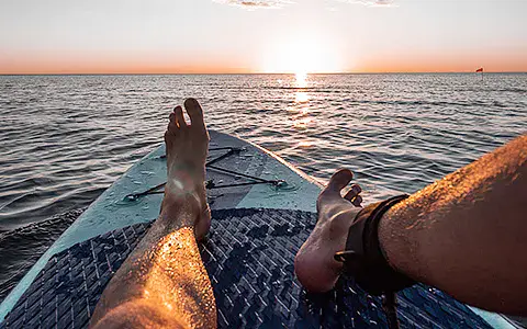 Planche de stand up paddle au coucher du soleil