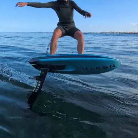 Pratiquant sur une planche à foil, casque rouge