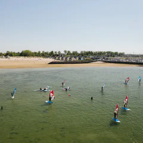 Vue aérienne d'un cours de planche à voile dans une eau peu profonde